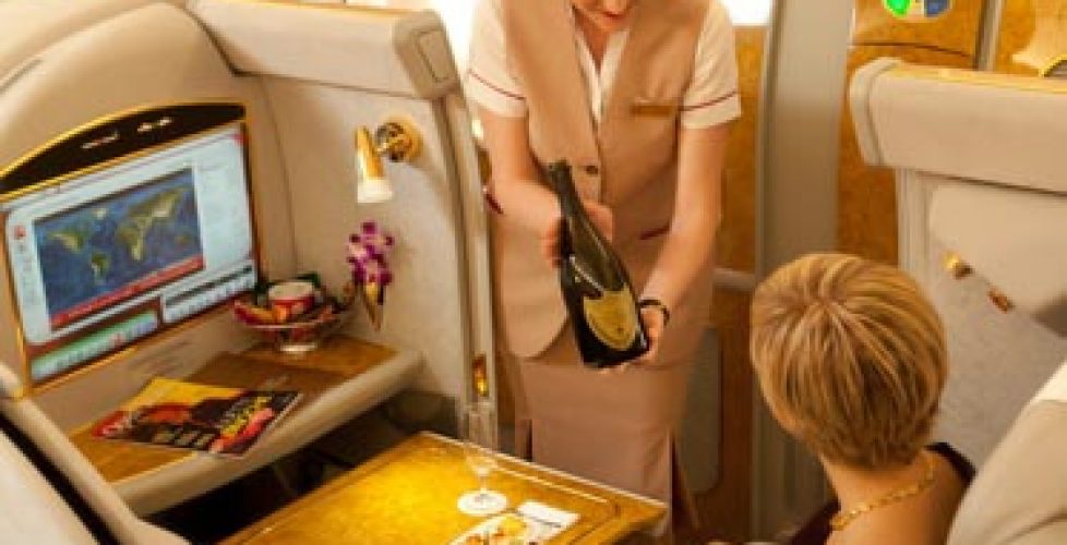 Flight attendant serving champagne on first class