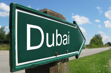 Green road sign pointing towards Dubai