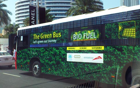 Green bus on the streets of Dubai