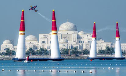 Airplane flies above the water in Abu Dhabi for the Red Bull Air Race