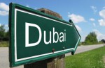 Green road sign pointing towards Dubai