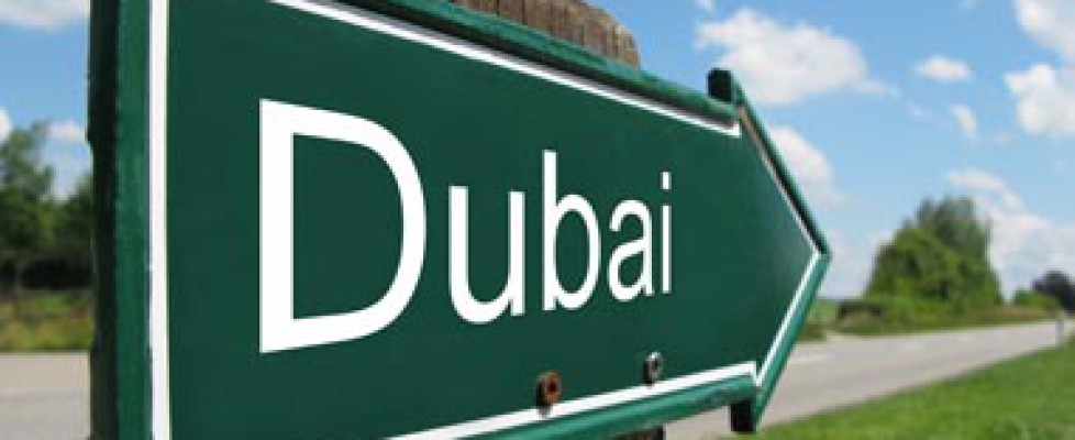 Green road sign pointing towards Dubai