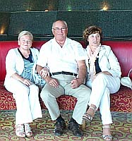 A man and two women are sitting in a hotel lobby